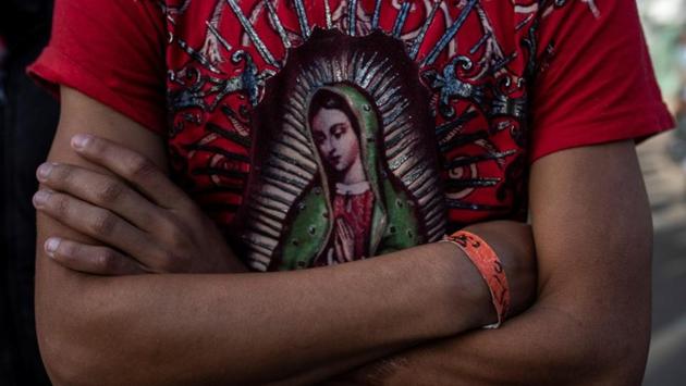 Herso, 17, from Honduras, poses for a picture wearing a T-shirt depicting the Virgin of Guadalupe outside a temporary shelter in Tijuana, Mexico. (Alkis Konstantinidis / Reuters) Herso, 17, from Honduras, poses for a picture wearing a T-shirt depicting the Virgin of Guadalupe outside a temporary shelter in Tijuana, Mexico. (Alkis Konstantinidis / Reuters)