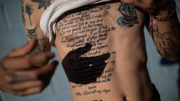 Juan Francisco, 25, from Honduras, shows his tattoo of Psalm 23 from the Book of Psalms as he poses for a picture outside a temporary shelter in Tijuana, Mexico. The migrants face a future of uncertainty. The United States said this month that many asylum seekers may be forced to stay in Mexico while their claims are processed. (Alkis Konstantinidis / Reuters) Juan Francisco, 25, from Honduras, shows his tattoo of Psalm 23 from the Book of Psalms as he poses for a picture outside a temporary shelter in Tijuana, Mexico. The migrants face a future of uncertainty. The United States said this month that many asylum seekers may be forced to stay in Mexico while their claims are processed. (Alkis Konstantinidis / Reuters)