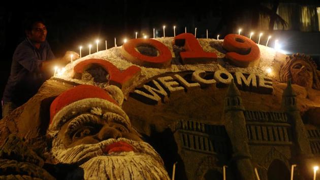 A man lights candles at a sand sculpture built to mark the New Year on a beach in Mumbai, India. (Francis Mascarenhas / Reuters) 