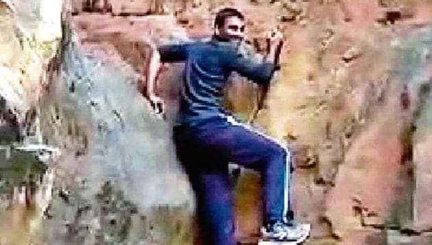 A video grab shows Praveen Tiwari climbing a rock at JNU campus. (Sourced) A video grab shows Praveen Tiwari climbing a rock at JNU campus. (Sourced)