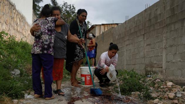 Ana Luz, a sister-in-law of Ronald Blanco, looked on grimly as neighbours of the murdered Honduran man washed away the rills of blood left where his bullet-ridden body had lain outside his house in a troubled barrio on the outskirts of Tegucigalpa. (Edgard Garrido / REUTERS) Ana Luz, a sister-in-law of Ronald Blanco, looked on grimly as neighbours of the murdered Honduran man washed away the rills of blood left where his bullet-ridden body had lain outside his house in a troubled barrio on the outskirts of Tegucigalpa. (Edgard Garrido / REUTERS)