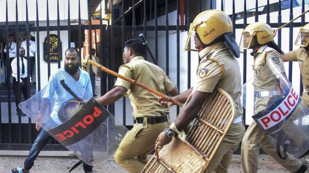 Policemen chase away a protester during a protest against the entry of two women to the Sabarimala temple, in Thiruvananthapuram on Wednesday.(PTI)