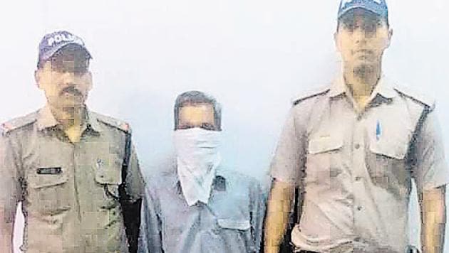 Suresh Singh (with covered face) in police custody. (HT Photo) Suresh Singh (with covered face) in police custody. (HT Photo)