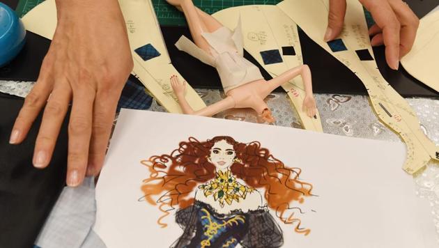 Stylist Carlyle Nuera works on fashion for Barbie doll prototypes at a workshop in the Mattel design center as the iconic doll turns 60. (Photo by Mark RALSTON / AFP) (AFP)