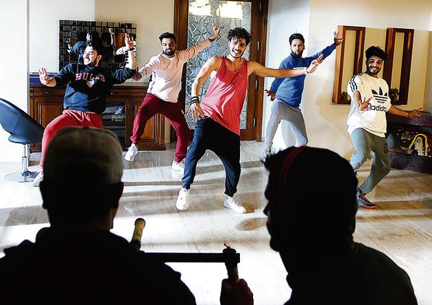 The culture in Mohali is encouraging, says Gurnazar Chattha, at centre above. Here, the singer and lyricist shoots his latest video, for a song called ‘Kudi kudi’, at an uncle’s bungalow. Local music labels release as many as 30 songs online a day. The music itself costs very little to produce and distribute, and within the formula — catchy beat, young dancers, lyrics about alcohol / partying / romance / heartbreak — some returns are almost guaranteed.(Anil Dayal / HT Photo)