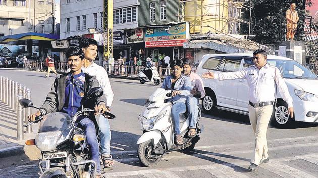 Police officials take action on helmetless riders at Lokmanya Tilak chowk.(RAVINDRA JOSHI/HT PHOTO)