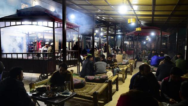 In this picture taken on December 6, 2018, Pakistani patrons enjoy eating grilled meat cooked on a barbeque at the Charsi (Hashish) Tikka restaurant in Namak Mandi in Peshawar.(AFP)