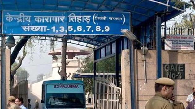 Policemen stand guard as an ambulance leaves the main entrance of Tihar Jail in New Delhi.(AFP Photo)