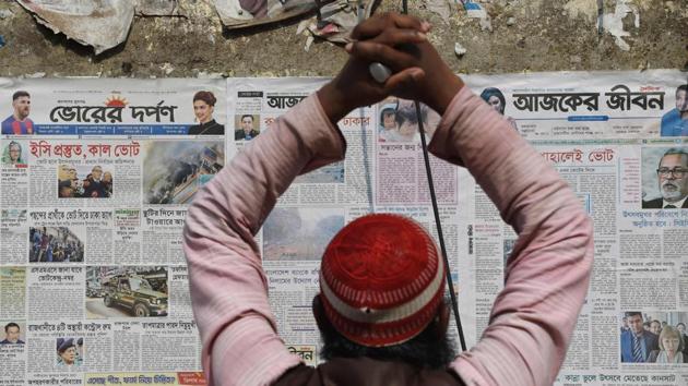 A Bangladeshi man reads election news on newspapers posted on a wall in Dhaka. (Indranil Mukherjee / AFP) A Bangladeshi man reads election news on newspapers posted on a wall in Dhaka. (Indranil Mukherjee / AFP)