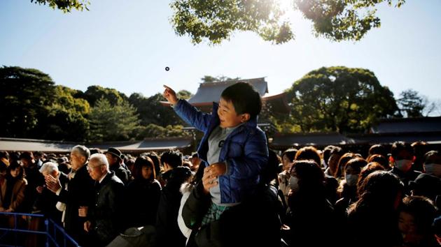 A boy throws a coin as he offers prayers on the first day of the new year at the Meiji Shrine in Tokyo, Japan. (Kim Kyung-Hoon / REUTERS) A boy throws a coin as he offers prayers on the first day of the new year at the Meiji Shrine in Tokyo, Japan. (Kim Kyung-Hoon / REUTERS)
