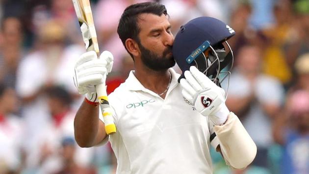 Cheteshwar Pujara kisses his helmet after reaching his century.(AFP)