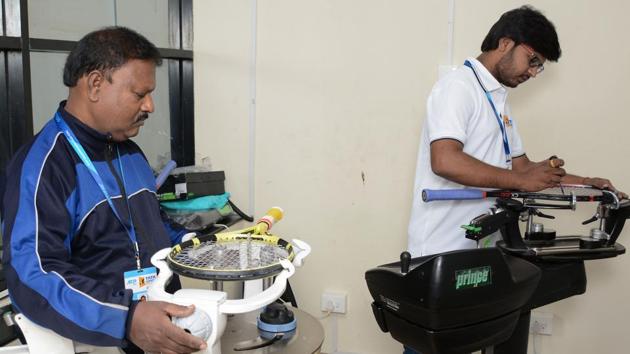 Dnyaneshwar Awaghade and Yuvraj Awaghade (in white T-shirt) while stringing the racquet at Balewadi Sports Complex in Pune.(Milind Saurkar/HT Photo)