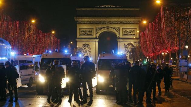 Riot police officers take position at the Champs Elysees avenue during a yellow vest protest in Paris on Saturday.(AP)