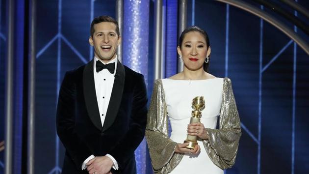 Host Sandra Oh holds her award for Best Actress - TV Series, Drama, Killing Eve while standing next to co-host Andy Samberg.(REUTERS)