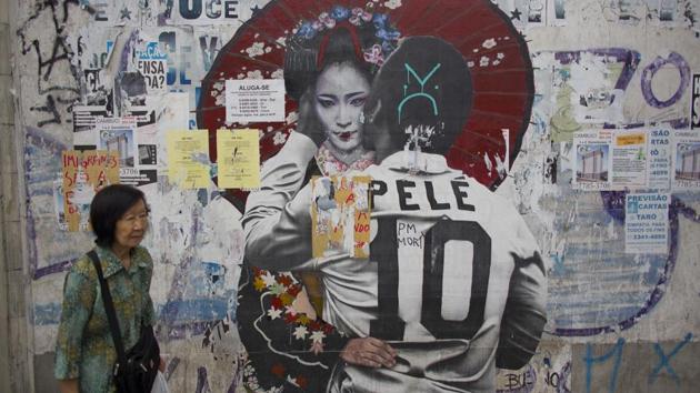 A woman walks by a mural of soccer legend Pele hugging a Geisha in Sao Paulo. Brazil’s first Japanese migrants arrived aboard the steamship Kasato Maru on June 18, 1908, spurring a wave that grew to about 2 million people. They introduced foods that changed Brazilian cuisine and farming techniques that helped turn Latin America’s biggest country into an agricultural superpower. (Victor R. Caivano / AP) A woman walks by a mural of soccer legend Pele hugging a Geisha in Sao Paulo. Brazil’s first Japanese migrants arrived aboard the steamship Kasato Maru on June 18, 1908, spurring a wave that grew to about 2 million people. They introduced foods that changed Brazilian cuisine and farming techniques that helped turn Latin America’s biggest country into an agricultural superpower. (Victor R. Caivano / AP)