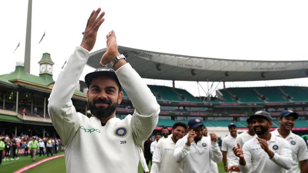 India's captain Virat Kohli gestures to supporters as his teammates celebrate a 2-1 series victory over Australia following play being abandoned on day five in the fourth Test at the SCG in Sydney. (REUTERS)