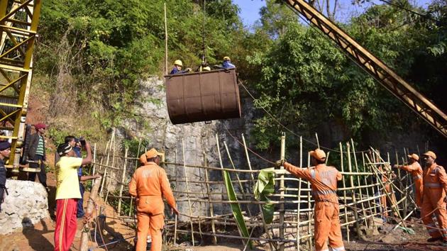 NDRF personnel gather around a crane as Navy divers are lifted with a pulley during rescue operations to help 15 miners trapped by flooding in an illegal coal mine in Ksan village in Meghalaya's East Jaintia Hills district.(AFP File Photo)