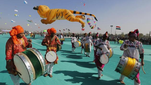 Artists plays drums during the kite festival. Uttarayan has become an integral cultural component to brand Gujarat and also helps boost local artisans who make these kites. (Ajit Solanki / AP) 