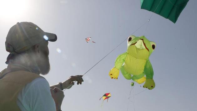 A kite flier hoists a frog shaped kite during the festival. Around 151 participants including nationals of the United States, United Kingdom, Cambodia and Nepal have arrived to participate in this event. (Siddharaj Solanki / HT Photo) 