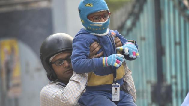 A man drops off his child to school. The Ghaziabad administration has ordered schools to remain close till January 12 due to the cold wave.(Sanchit Khanna/HT Photo)