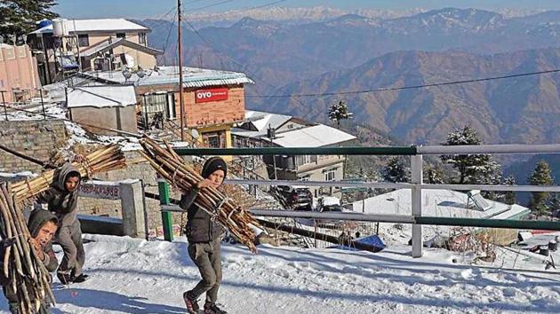 Children carrying wooden sticks home after snowfall at Kufri near Shimla on Monday. Many areas in Himachal Pradesh have been witnessing intermittent snow spell , snapping road and electricity connectivity across various regions. (HT Photo) Children carrying wooden sticks home after snowfall at Kufri near Shimla on Monday. Many areas in Himachal Pradesh have been witnessing intermittent snow spell , snapping road and electricity connectivity across various regions. (HT Photo)