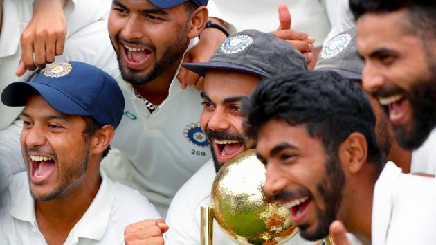 India's captain Virat Kohli (C) celebrates with teammates as they pose with the Border-Gavaskar Trophy.(AFP)