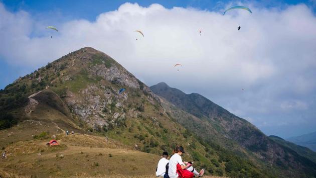 Hikers rest on the grass as paragliders fly above Ma On Shan peak. “Hong Kong is very crowded and there are always many people wherever you go... but once you are off in the sky, you are free,” Lam told AFP. “It feels like there are no chains or constraints.” (Anthony Wallace / AFP) Hikers rest on the grass as paragliders fly above Ma On Shan peak. “Hong Kong is very crowded and there are always many people wherever you go... but once you are off in the sky, you are free,” Lam told AFP. “It feels like there are no chains or constraints.” (Anthony Wallace / AFP)