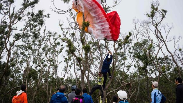 People attempt to loosen a wing after a paraglider crash landed into a tree. In July, experienced Hong Kong paraglider Patrick Chung Yuk-Wa -- a friend of Lam’s -- failed to come back from a flight during squally conditions as a typhoon neared the region. With grim weather conditions setting in after he was reported missing, it took five days to locate and retrieve Chung’s body. (Anthony Wallace / AFP) People attempt to loosen a wing after a paraglider crash landed into a tree. In July, experienced Hong Kong paraglider Patrick Chung Yuk-Wa -- a friend of Lam’s -- failed to come back from a flight during squally conditions as a typhoon neared the region. With grim weather conditions setting in after he was reported missing, it took five days to locate and retrieve Chung’s body. (Anthony Wallace / AFP)