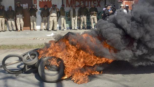 Police personnel look on as tyres are seen ablaze during a strike called by All Assam Students’ Union (AASU) and the North East Students’ Organisation (NESO) in protest against Citizenship (Amendment) Bill, 2016, in Dibrugarh on Jan 8. (PTI Photo) Police personnel look on as tyres are seen ablaze during a strike called by All Assam Students’ Union (AASU) and the North East Students’ Organisation (NESO) in protest against Citizenship (Amendment) Bill, 2016, in Dibrugarh on Jan 8. (PTI Photo)