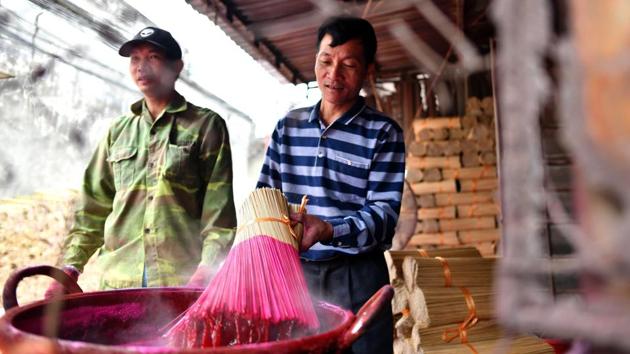 Most households in the alleys of Quang Phu Cau are involved in the ancient trade. Some hack bamboo planks down to be fed into a whittling machine; others dip the thin strips into buckets of pink dye, leaving hundreds of brightly coloured bushels fanned out like bouquets on the streets to air out. (Manan Vatsyayana / AFP) Most households in the alleys of Quang Phu Cau are involved in the ancient trade. Some hack bamboo planks down to be fed into a whittling machine; others dip the thin strips into buckets of pink dye, leaving hundreds of brightly coloured bushels fanned out like bouquets on the streets to air out. (Manan Vatsyayana / AFP)