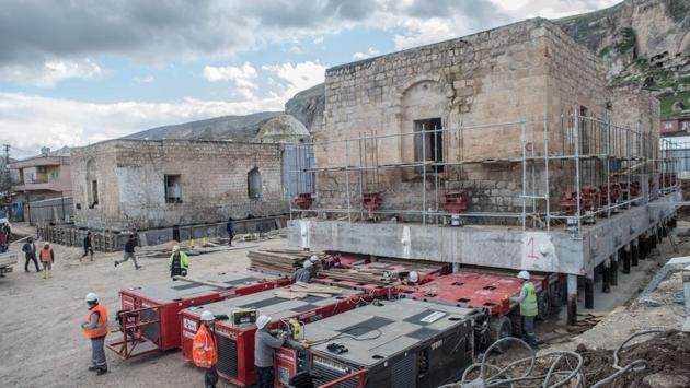 In one lengthy operation last August, the 1,600-tonne Artuklu Hamam bath house was loaded onto a wheeled platform and moved down a special road to its new home. Workers also recently moved the remnants of a 14th-century Ayyubid mosque (pictured), transporting it three kilometres to a site that will become a “cultural park”. Such relocations have turned Hasankeyf into a construction site. (Bulent Kilic / AFP) In one lengthy operation last August, the 1,600-tonne Artuklu Hamam bath house was loaded onto a wheeled platform and moved down a special road to its new home. Workers also recently moved the remnants of a 14th-century Ayyubid mosque (pictured), transporting it three kilometres to a site that will become a “cultural park”. Such relocations have turned Hasankeyf into a construction site. (Bulent Kilic / AFP)