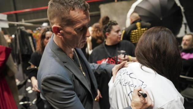 Moschino fashion designer Jeremy Scott autographs a t-shirt at the end of the fall-winter 2019/20 men’s collection and women’s pre-collection (AP)
