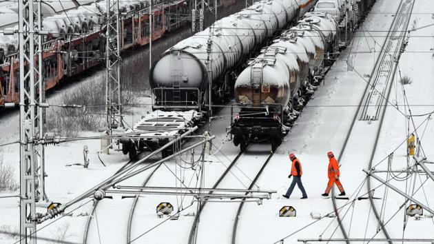 Employees of a freight train terminal walk in front of freight trains in Munich, Germany. On Monday, 11 German hikers had to be rescued from a cabin near Salzburg, after having been snowed in since Friday. People were killed by avalanches in Switzerland, Austria and Germany, and authorities warned that continuing snowfall is increasing the risk of more avalanches. (Christof Stache / AFP) Employees of a freight train terminal walk in front of freight trains in Munich, Germany. On Monday, 11 German hikers had to be rescued from a cabin near Salzburg, after having been snowed in since Friday. People were killed by avalanches in Switzerland, Austria and Germany, and authorities warned that continuing snowfall is increasing the risk of more avalanches. (Christof Stache / AFP)