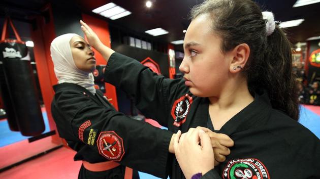 Asma Hasnawi (L), practises with her daughter Riham. The girls pair up to take what they have learnt and put it to practise. On the walls of the Street Warrior Academy is a poster of two men practising the sport. “Kajukenbo teaches your child the methods and arts of self-defence,” it read, complimenting the mottos of “strength and honour” and “street warrior” on the backs of the girls’ uniforms. (Yasser Al-Zayyat / AFP) Asma Hasnawi (L), practises with her daughter Riham. The girls pair up to take what they have learnt and put it to practise. On the walls of the Street Warrior Academy is a poster of two men practising the sport. “Kajukenbo teaches your child the methods and arts of self-defence,” it read, complimenting the mottos of “strength and honour” and “street warrior” on the backs of the girls’ uniforms. (Yasser Al-Zayyat / AFP)
