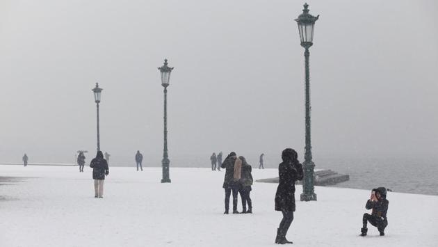 People walk on the seaside promenade during snowfall in Thessaloniki. The weather spell led to heavy rain and snow on the Mediterranean island of Cyprus, which is more used to protracted periods of drought. (Alexandros Avramidis / REUTERS) People walk on the seaside promenade during snowfall in Thessaloniki. The weather spell led to heavy rain and snow on the Mediterranean island of Cyprus, which is more used to protracted periods of drought. (Alexandros Avramidis / REUTERS)