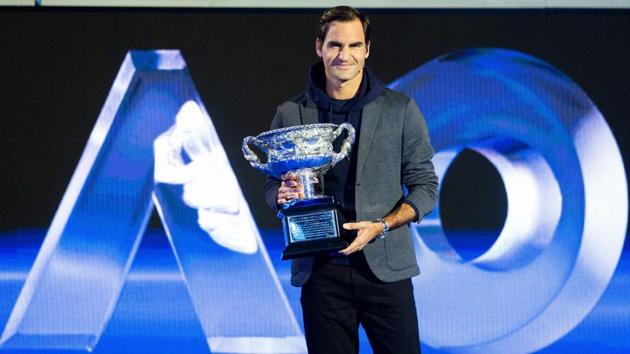 Roger Federer poses with the men's singles trophy during the draw for the Australian Open.(AFP)