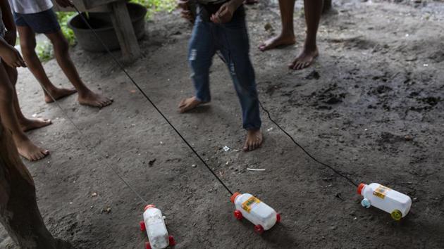 A sign of the poverty — and also the innocence of childhood — kids play with trucks made of plastic juice boxes with lids for wheels. For many grown-ups, the only option they’ve found to cope with poverty is diving, no matter the risks. (Rodrigo Abd / AP) A sign of the poverty — and also the innocence of childhood — kids play with trucks made of plastic juice boxes with lids for wheels. For many grown-ups, the only option they’ve found to cope with poverty is diving, no matter the risks. (Rodrigo Abd / AP)