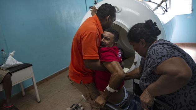 Cedrack Waldan Mendoza (L), the physical therapist operating the chamber, said divers are driven by poverty, and even if injured, return to the boats. “You run into them in the street and ask them why they’re going (back to diving) and they say it’s because their kids are hungry,” Mendoza said. “When someone tells you that their kids are hungry there’s no need to ask another question.” (Rodrigo Abd / AP) Cedrack Waldan Mendoza (L), the physical therapist operating the chamber, said divers are driven by poverty, and even if injured, return to the boats. “You run into them in the street and ask them why they’re going (back to diving) and they say it’s because their kids are hungry,” Mendoza said. “When someone tells you that their kids are hungry there’s no need to ask another question.” (Rodrigo Abd / AP)