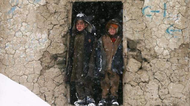 Internally displaced Afghan boys stand outside their shelter during snowfall in Kabul, Afghanistan. (Mohammad Ismail / REUTERS) Internally displaced Afghan boys stand outside their shelter during snowfall in Kabul, Afghanistan. (Mohammad Ismail / REUTERS)