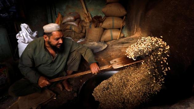 A man roasts peanuts for sale at a shop in Peshawar, Pakistan. (Fayaz Aziz / REUTERS) A man roasts peanuts for sale at a shop in Peshawar, Pakistan. (Fayaz Aziz / REUTERS)