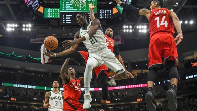 Milwaukee Bucks guard Tony Snell (21) takes a shot in the third quarter against Toronto Raptors guard Delon Wright (55) and guard Danny Green (14) at the Fiserv Forum in Milwaukee, Wisconsin. (Benny Sieu / USA Today via REUTERS) Milwaukee Bucks guard Tony Snell (21) takes a shot in the third quarter against Toronto Raptors guard Delon Wright (55) and guard Danny Green (14) at the Fiserv Forum in Milwaukee, Wisconsin. (Benny Sieu / USA Today via REUTERS)