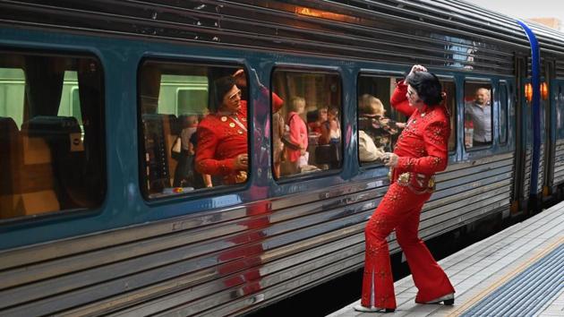 An Elvis fan uses the train window as a mirror before boarding a train to The Parkes Elvis Festival. The revellers at Central station were boarding the “Elvis Express” and “Blue Suede Express”, two trains put on to take them to the small outback town of Parkes, 300 kilometres west of Sydney. (Peter Parks / AFP) An Elvis fan uses the train window as a mirror before boarding a train to The Parkes Elvis Festival. The revellers at Central station were boarding the “Elvis Express” and “Blue Suede Express”, two trains put on to take them to the small outback town of Parkes, 300 kilometres west of Sydney. (Peter Parks / AFP)