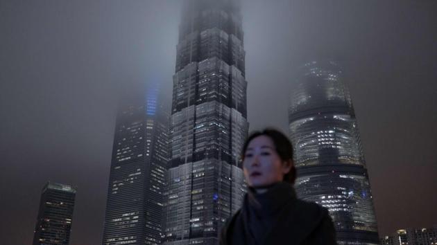 TOPSHOT - In this photo taken on January 10, 2019, a woman walks on a pedestrian bridge in Shanghai's Lujiazui financial district. (Photo by MATTHEW KNIGHT / AFP)(AFP)