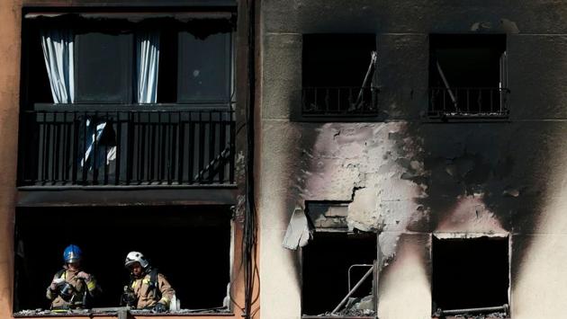 Firefighters check the damage after extinguishing a fire that broke out at an apartment building in Badalona near Barcelona. At least three people were killed and several others, including a baby, were injured. (Pau Barrena / AFP) Firefighters check the damage after extinguishing a fire that broke out at an apartment building in Badalona near Barcelona. At least three people were killed and several others, including a baby, were injured. (Pau Barrena / AFP)