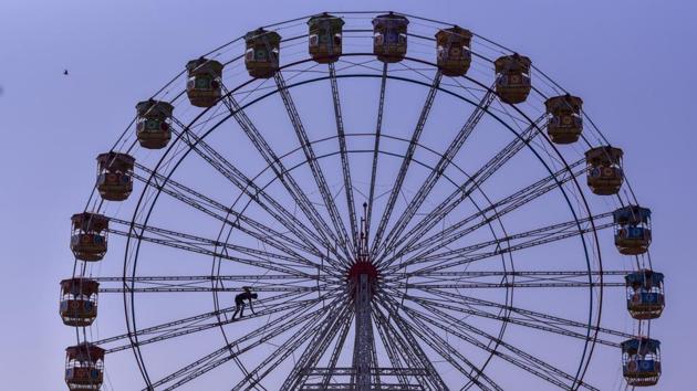 A man is seen working on the Ferris wheel for a fair at Dharavi in Mumbai, Maharashtra. (Kunal Patil / HT Photo) A man is seen working on the Ferris wheel for a fair at Dharavi in Mumbai, Maharashtra. (Kunal Patil / HT Photo)