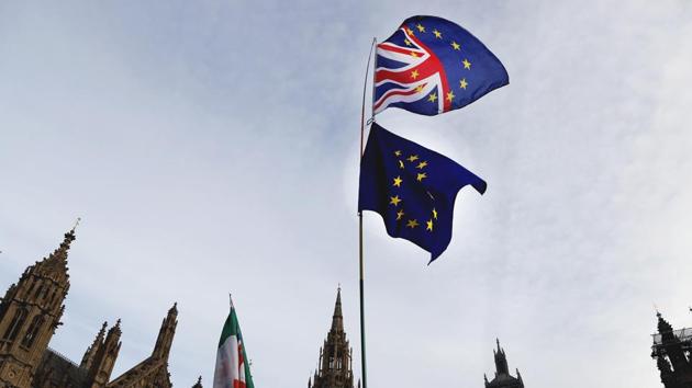 A Pro-European demonstrator raises flags to protest outside parliament in London, Friday, Jan. 11, 2019. Britain's Prime Minister Theresa May is struggling to win support for her Brexit deal in Parliament. Lawmakers are due to vote on the agreement Tuesday, and all signs suggest they will reject it, adding uncertainty to Brexit less than three months before Britain is due to leave the EU on March 29. (AP Photo/Frank Augstein)(AP)