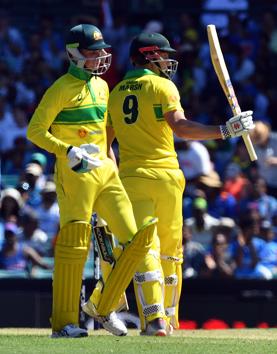 Australia's batsman Shaun Marsh (R) celebrates reaching his half century (50 runs) as his teammate Australia's Peter Handscomb looks on during the first one-day International (ODI) match between Australia and India at the Sydney Cricket Ground. (AFP)