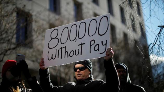 A demonstrator holds a sign, signifying hundreds of thousands of federal employees who won’t be receiving their paychecks as a result of the partial government shutdown, during a “Rally to End the Shutdown” in Washington, U.S., Jan. 10, 2019 (File Photo)(REUTERS)