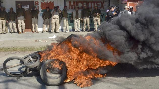 Police personnel look on as tyres are seen ablaze during a strike called by All Assam Students’ Union (AASU) and the North East Students’ Organisation (NESO) in protest against Citizenship (Amendment) Bill, 2016 in Dibrugarh, Assam. (PTI) Police personnel look on as tyres are seen ablaze during a strike called by All Assam Students’ Union (AASU) and the North East Students’ Organisation (NESO) in protest against Citizenship (Amendment) Bill, 2016 in Dibrugarh, Assam. (PTI)