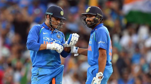 Mahendra Singh Dhoni (left) and Rohit Sharma speak during their partnership in the first ODI at the Sydney Cricket Ground.(AFP)